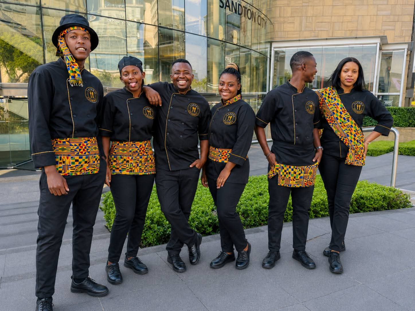 The Lapeng Gourmet team in branded black and gold uniforms outside Sandton City